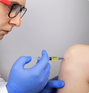 doctor making an injection in the knee of a patient